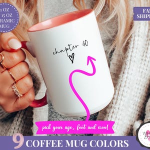 May include: White ceramic mug with a pink interior and handle, featuring the text "chapter 40" with a heart and a pink arrow. The mug is available in 9 colors and comes in 11 oz and 15 oz sizes. The mug is a coffee mug.