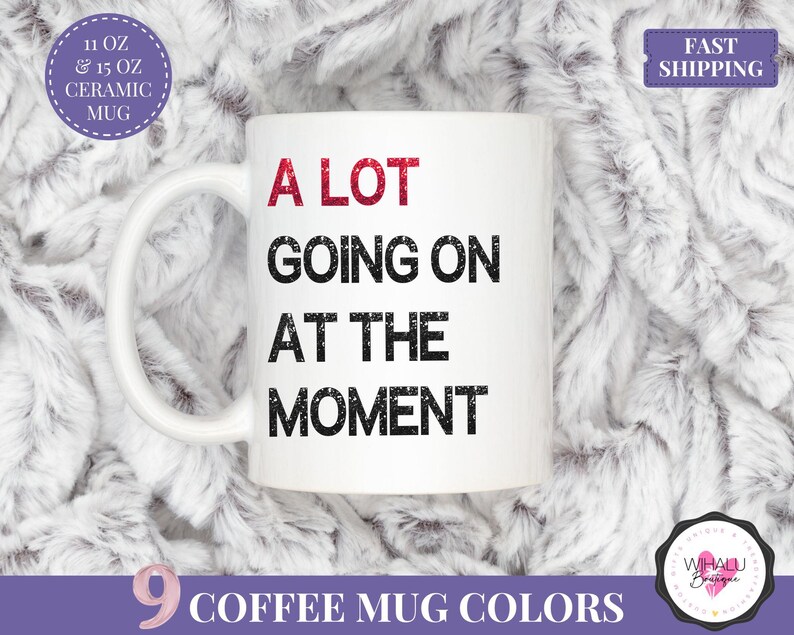 Puede incluir: Taza de caf&eacute; de cer&aacute;mica blanca con el texto "A LOT GOING ON AT THE MOMENT" en negro y rojo. La taza est&aacute; disponible en 9 colores y en tama&ntilde;os de 11 oz y 15 oz.
