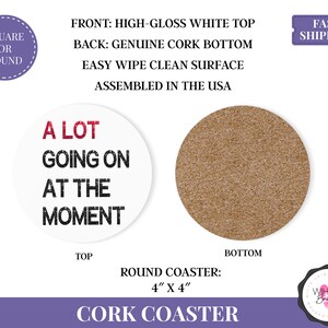 Puede incluir: Un posavasos redondo de corcho blanco con el texto "A LOT GOING ON AT THE MOMENT" en negro y rojo. El posavasos mide 10 cm por 10 cm. La parte trasera es de corcho aut&eacute;ntico.
