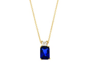 Baguette shaped pendant with one central piece in blue color and one more clear zircon at the top of it made of solid yellow gold 14c.