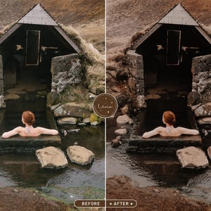 May include: A woman relaxes in a natural hot spring pool, surrounded by rocks and a stone building. The water is clear and the sky is overcast.