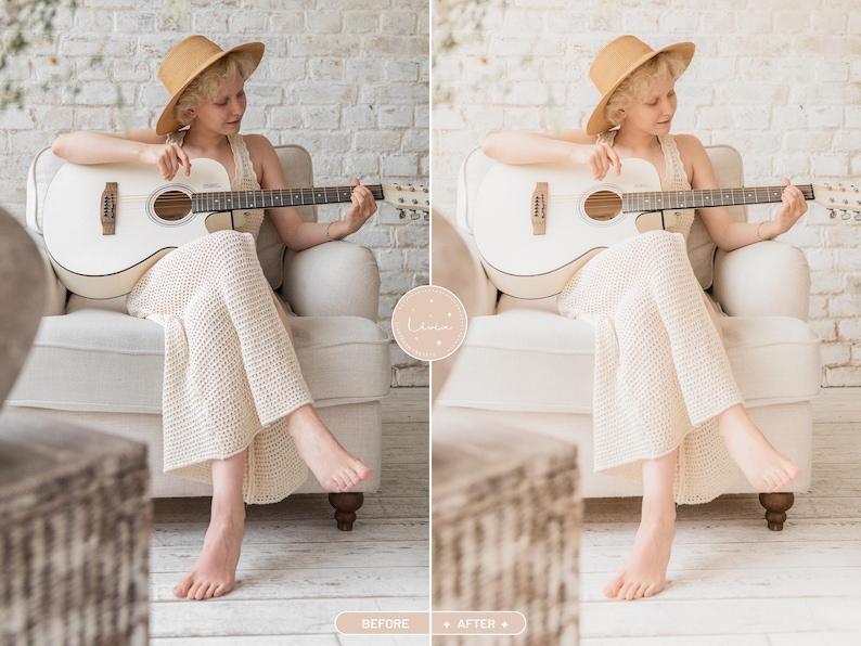 May include: A white acoustic guitar with a dark fretboard and bridge, held by a person wearing a tan wide-brimmed hat and a cream-colored textured knit dress, seated in a light-colored upholstered armchair against a white brick wall.