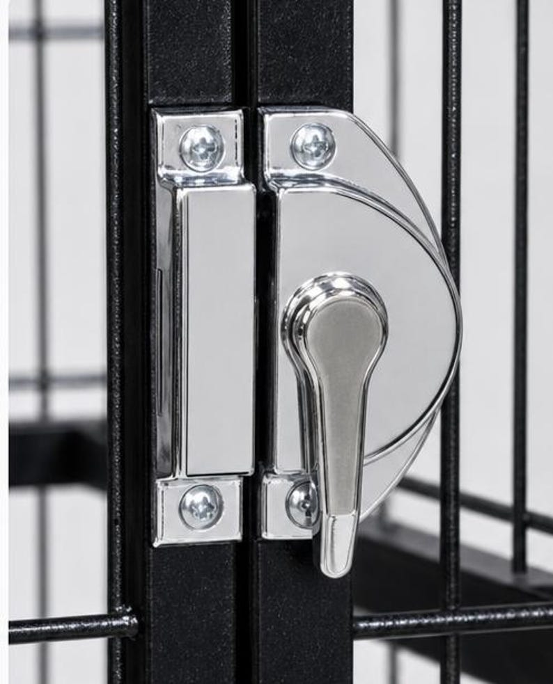 May include: A black metal wire cage door featuring a polished chrome latch mechanism. The latch consists of a rectangular strike plate and a semi-circular handle assembly, both secured with visible silver screws to the vertical frame bars.