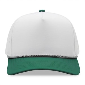 May include: A white and green baseball cap with a curved brim. The cap features a white front panel, a green brim, and a green button on top. A black and white rope detail accents the brim.