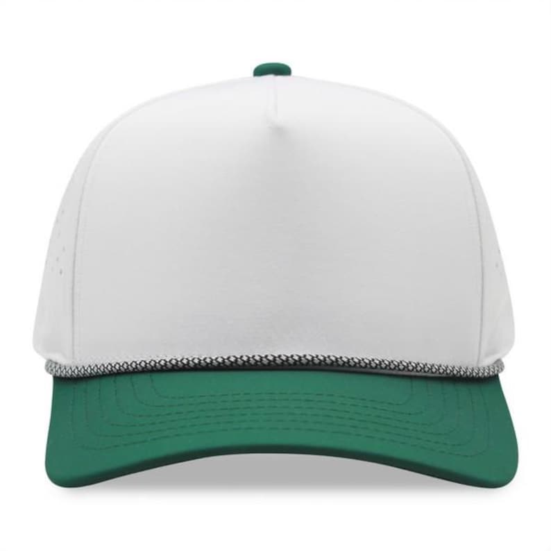 May include: A white and green baseball cap with a curved brim. The cap features a white front panel, a green brim, and a green button on top. A black and white rope detail accents the brim.