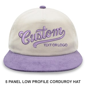 Puede incluir: Gorra de béisbol de pana crema y lavanda. La palabra "Custom" está bordada en escritura lavanda, con "TEXT OR LOGO" debajo. Diseño de 5 paneles, de perfil bajo.