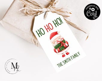 May include: White gift tag with green text that says "Ho Ho Ho!" and a cartoon image of Santa Claus holding a wrapped gift. The text "The Smith Family" is printed below the image.