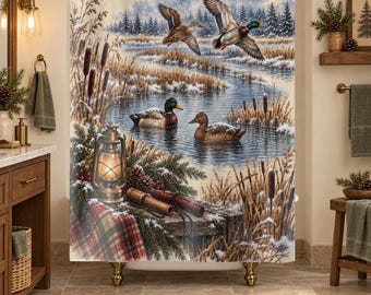 May include: A shower curtain featuring a winter landscape with two ducks flying over a stream and two ducks swimming in the water. The scene includes cattails, a lit lantern, a plaid blanket, and pine branches covered in light snow.