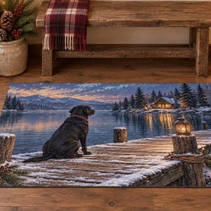 Könnte beinhalten: Eine rechteckige Fußmatte mit einem aufgedruckten Motiv eines schwarzen Labradors, der in der Dämmerung auf einem verschneiten Holzsteg sitzt. Das Bild zeigt einen ruhigen See, ferne schneebedeckte Berge, eine beleuchtete Hütte und eine Laterne.