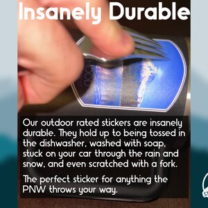 May include: A sticker featuring a mountain landscape graphic applied to a dark surface, with a metal fork scraping across the surface. The text reads Insanely Durable, Our outdoor rated stickers are insanely durable, and STICKERSHOP PNW.