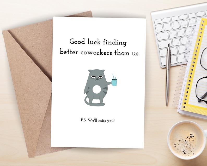 May include: A white card with a gray cat cartoon holding a blue coffee cup. The card reads "Good luck finding better coworkers than us." and "P.S. We'll miss you!"