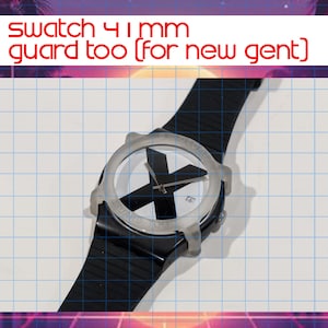 May include: A black Swatch watch with a clear guard, featuring a white face with a large black X design. The watch has a black strap and the text "swatch 41mm guard too (for new gent)" is visible.