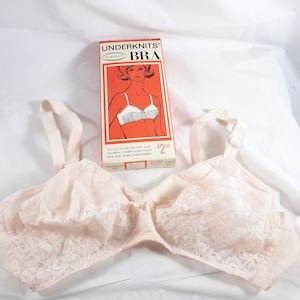 May include: A vintage white lace bra with a three-section cup bandeau. The bra is shown on a white background with a red and white box that reads "Underknits Bra" and "$2.50".