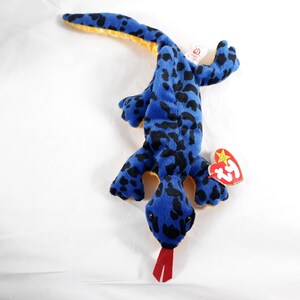 May include: Blue and black spotted plush lizard with a red tongue and a Ty Beanie Baby tag.