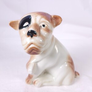 May include: A white ceramic mug with a black handle and the text "But First, Coffee" in a bold, black font. The mug is set against a neutral background, highlighting its simple design.