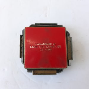 May include: A red metal matchbook with the text "Compliments of LESH OIL COMPANY - CE 2-3132" printed in white.