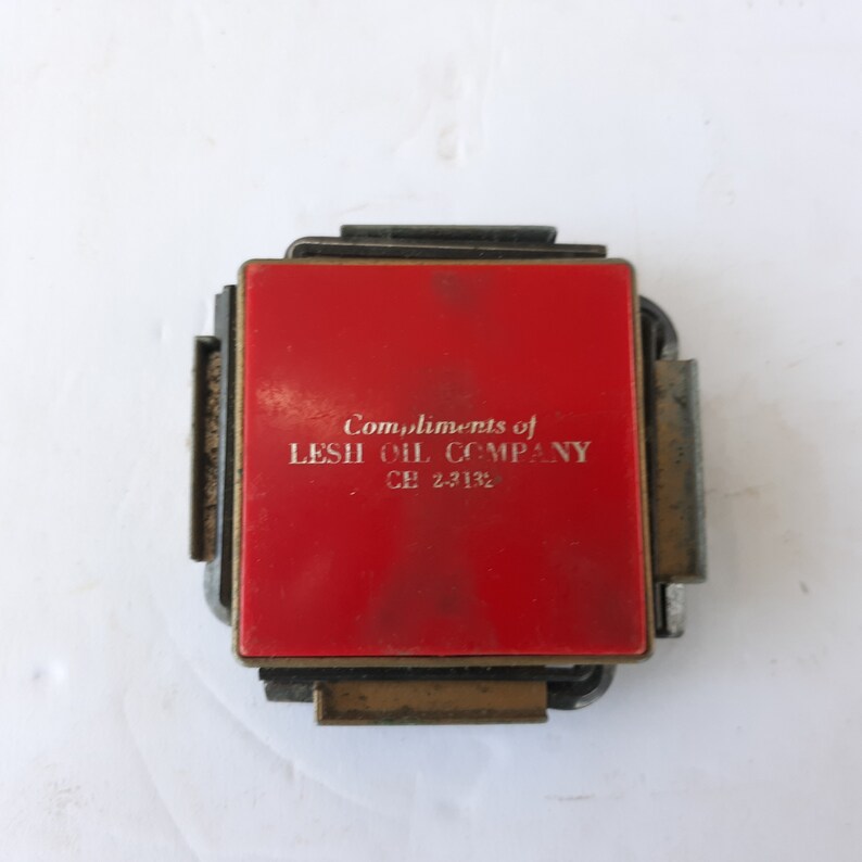 May include: A red metal matchbook with the text "Compliments of LESH OIL COMPANY - CE 2-3132" printed in white.