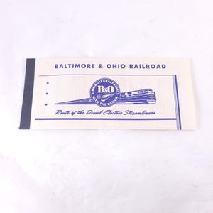 May include: A vintage Baltimore & Ohio Railroad ticket or brochure. The cream-colored paper features blue text and graphics, including the B&O logo and a streamlined train. The text reads "BALTIMORE & OHIO RAILROAD" and "Route of the Diesel Electric Streamliners."