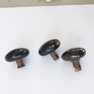 May include: Three black ceramic door knobs with rusty metal stems.