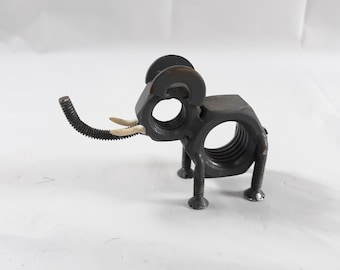 May include: A small metal elephant sculpture made from nuts and bolts. The elephant is gray and has white tusks. It is standing on a white surface.