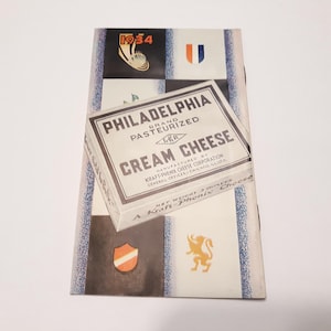 May include: A vintage Kraft-Phenix Philadelphia Cream Cheese box with a blue and white checkered background. The box is labeled "Philadelphia Brand Pasteurized Cream Cheese" and features the Kraft-Phenix logo. The box is 3 ounces.