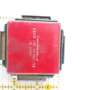 May include: A red metal tag with the text "Compliments of LESH OIL COMPANY CE 2-3182".