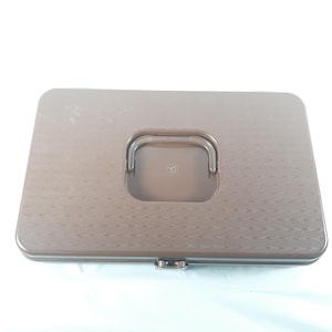 May include: A brown plastic storage box with a textured lid and a built-in handle. The box has a latch on the front.
