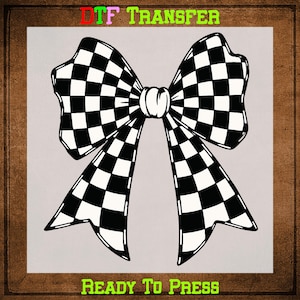 May include: A black and white checkered bow design. The bow is centered on a light gray background, with the words "DTF TRANSFER" at the top and "READY TO PRESS" at the bottom. The image is framed with a brown border.