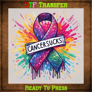 May include: A colorful graphic design of a pink and purple ribbon with glitter and a banner that says "CANCERSUCKS". The ribbon is dripping with colorful paint and surrounded by a burst of colorful paint splatters. The text "DTG TRANSFER READY TO PRESS" is at the top and bottom of the image.