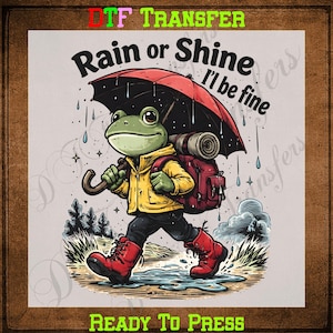 May include: A whimsical illustration features a frog wearing a yellow jacket, red boots, and a backpack, holding an umbrella. The text "Rain or Shine I'll be fine" is above the frog. The words "DTF TRANSFER" and "READY TO PRESS" are also visible.