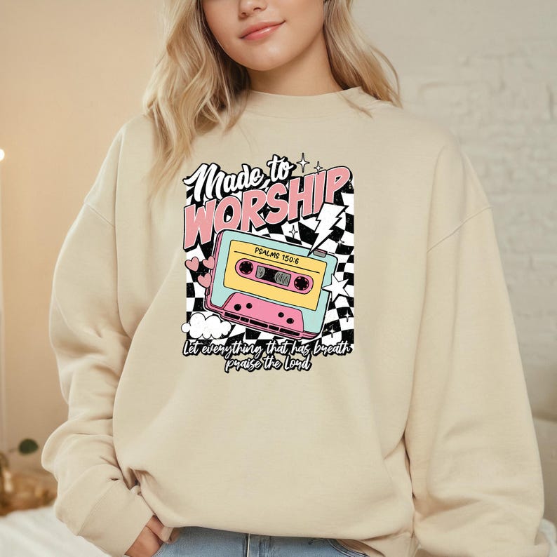 May include: A beige sweatshirt with a graphic print of a cassette tape and the text "Made to Worship" with the Bible verse "Psalms 150:6" and the phrase "Let everything that has breath praise the Lord".