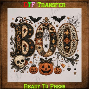 May include: A DTF TRANSFER READY TO PRESS graphic featuring the word BOO in large, ornate, quilted-style letters with black, orange, and cream patterns. The design includes a skull, three jack-o'-lanterns, bats, a spider web, and stars.