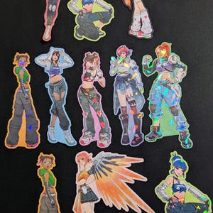 May include: A handmade wooden sign with the text "Welcome" in a handwritten style. The sign is painted white with a distressed finish, and a small, decorative heart is attached. The sign measures approximately 12 inches wide.