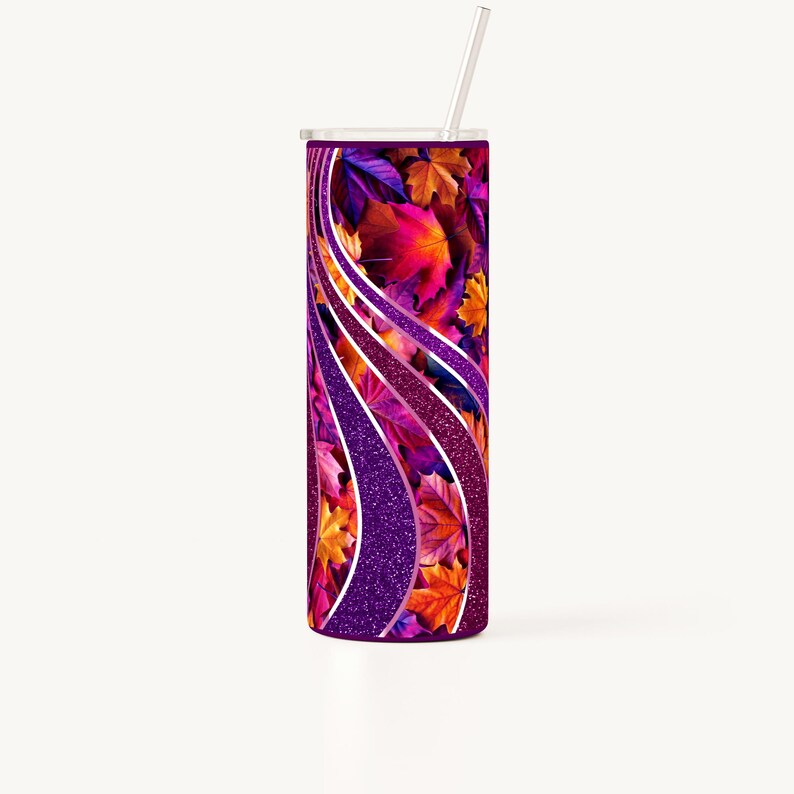 May include: A purple and silver tumbler with a fall leaf design. The leaves are in shades of orange, red, and yellow. The tumbler has a straw.
