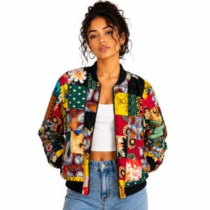 May include: A bomber jacket featuring a vibrant patchwork design with various colorful patterns including floral, geometric, and abstract motifs in shades of red, yellow, green, and blue, finished with a black ribbed collar, cuffs, and hem.