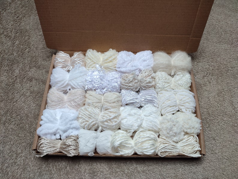 Mixed pack of 20 yarn bundles in creams, whites and neutrals with various weights, types and textures.