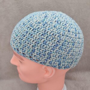 Peut inclure: Un bonnet en crochet bleu et blanc avec un motif texturé.