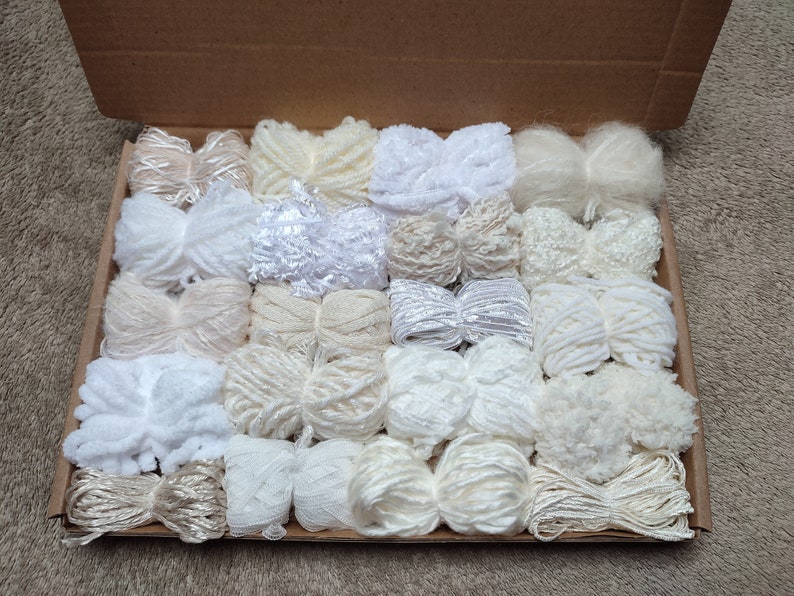 Mixed pack of 20 yarn bundles in creams, whites and neutrals with various weights, types and textures.