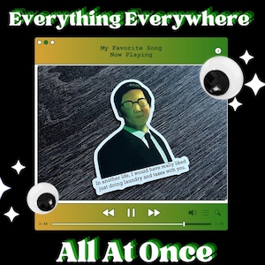 May include: A black graphic design featuring text that reads "Everything Everywhere All At Once." The design includes a sticker of a man in a suit, a music player interface, and googly eyes.