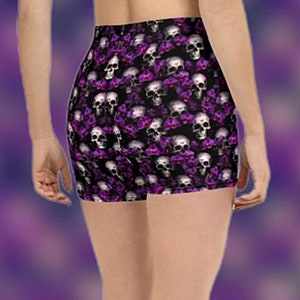 Può includere: Shorts sportivi neri con stampa di teschi e fiori viola e bianchi.
