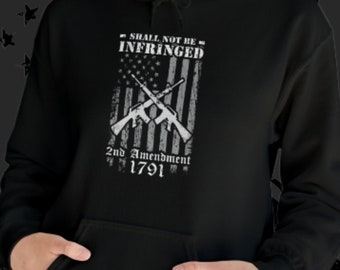 May include: Black hoodie with a white graphic of a crossed rifle design with an American flag background. The text reads "Shall Not Be Infringed" and "2nd Amendment 1791".