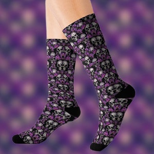 May include: A pair of black socks with a purple and white skull and flower pattern.