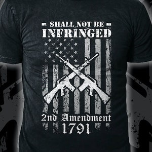 May include: Black t-shirt with a white distressed American flag design. The flag has two crossed rifles and the text "Shall Not Be Infringed" and "2nd Amendment 1791".