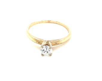 May include: A gold solitaire ring with a single round diamond.