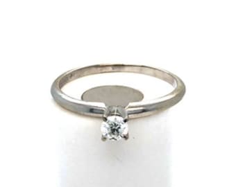 May include: A simple silver band ring with a single, small, round diamond.