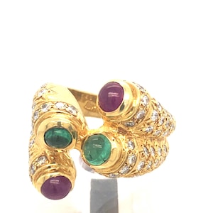 May include: A gold ring with three cabochon gemstones: two pink and one green. The ring is set with small diamonds around the gemstones and the band.
