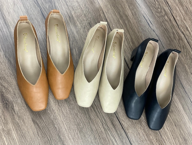 May include: Five pairs of women's shoes in different colours. The shoes are all pointed-toe flats with a v-shaped opening at the front. The shoes are in brown, beige, and black.
