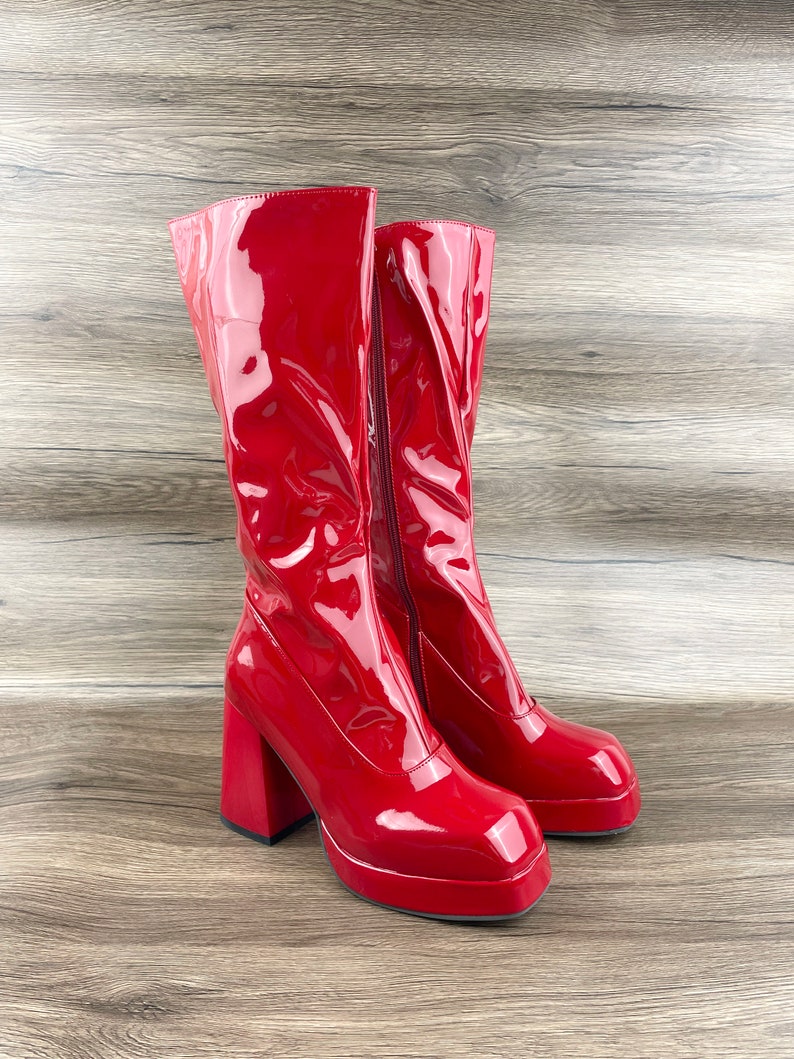 K&ouml;nnte beinhalten: Ein Paar rote Lackleder-Plateau-Stiefel mit einem dicken Absatz.
