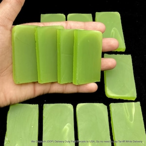 May include: A collection of rectangular, translucent light green bars with smooth surfaces. Four bars are held in a palm, while several others are arranged in rows on a black surface. The text at the bottom reads: We Dispatch (DDP) Delivery Duty Paid Parcels to USA, So no need to pay Tarriff While Delivery.