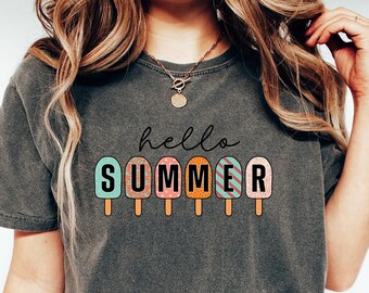 May include: Dark gray t-shirt with the words "hello SUMMER" printed on the front. The word "SUMMER" is designed with colorful popsicle graphics. The shirt is a casual style.